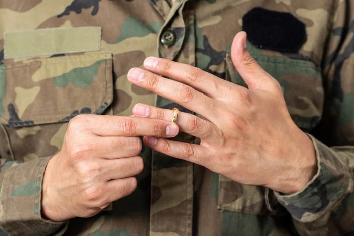 military member holding his ring while going through a divorce